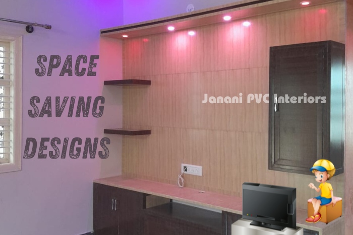 Space-saving PVC interior design by Janani PVC Interiors in Bengaluru, featuring wall-mounted shelves and cabinets with ambient pink lighting, perfect for compact homes looking to enhance functionality and style