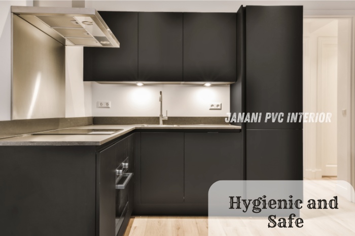 Sleek and modern PVC modular kitchen by Janani PVC Interior Design in Bengaluru, featuring black cabinets and stainless steel fixtures. Emphasizes the hygienic and safe properties of PVC materials for a stylish and functional kitchen space